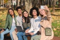 Cheerful teenagers sitting on bench and taking selfie Royalty Free Stock Photo