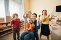 cheerful interracial kids with young teacher