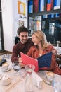 Cheerful jolly couple organizing date at cafe