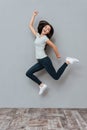 Cheerful joyful young woman jumping and having fun