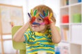 Cute cheerful kid boy showing hands painted in bright colors Royalty Free Stock Photo