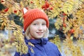 Cheerful kid girl smiling, the child is dressed in a funny knitted warm hat with ears, looks like a fox. Autumn, outdoors portrait Royalty Free Stock Photo