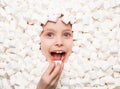 Cheerful kid posing in white marshmallows Royalty Free Stock Photo