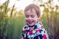 Cheerful kid toddler laughing outdoors. Child portrait in nature. Caucasian White boy. Royalty Free Stock Photo