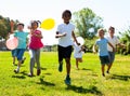 Cheerful kids with balloons are jogging together in the park and having fun Royalty Free Stock Photo