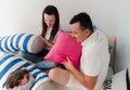 Cheerful kids and parents having pillow fight on bed at home Royalty Free Stock Photo