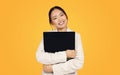 Cheerful korean millennial woman in suit hugs laptop with blank screen, enjoy chatting