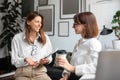 Cheerful lady coworkers enjoying coffee break, two businesswomen talking, meeting and chatting in office Royalty Free Stock Photo