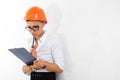 Cheerful lady with short dark hair, in beautiful office suit, orange comstruction helmet plans something with tablet Royalty Free Stock Photo