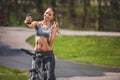 Grinning athletic girl is shooting in sunny park Royalty Free Stock Photo