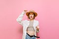 Cheerful lady tourist in summer clothes and sun hat dancing on pink background with closed eyes on pink. Positive elderly girl Royalty Free Stock Photo