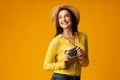 Cheerful lady traveler holding retro camera posing in studio Royalty Free Stock Photo