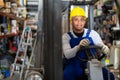 Cheerful worker of building materials warehouse driving forklift