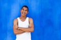 Cheerful latin guy in front of a blue wall