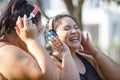 Cheerful laugh smiling friends young asian woman happy wear headphone listen to music in sportswear walking after exercise. Two Royalty Free Stock Photo
