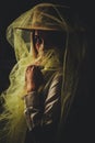 Cheerful laughing girl with brown hat wrapped in tulle on a dark background Royalty Free Stock Photo