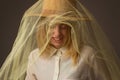 Cheerful laughing girl with brown hat wrapped in tulle on a dark background Royalty Free Stock Photo