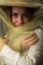 Cheerful laughing girl with brown hat wrapped in tulle on a dark background Royalty Free Stock Photo