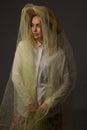 Cheerful laughing girl with brown hat wrapped in tulle on a dark background Royalty Free Stock Photo