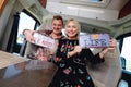 Couple sitting inside of camper holds hippy retro styled number plates
