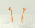 Cheerful lazy woman waking up after sleeping lying in soft comfortable bed showing gesture stretching her hands up from under the