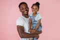 Cheerful little african american girl with bushy hair smiling on daddy's hands young man Royalty Free Stock Photo