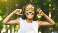 Cheerful little african-american girl with face painting like tiger Royalty Free Stock Photo