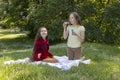 Cheerful Little Asian Caucasian Girls Of Elementary School Age Blowing Soap Bubbles In Royalty Free Stock Photo