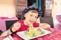 Cheerful little boy enjoying eating italian food - Portrait of happy smiling kid eating seafood pasta for lunch