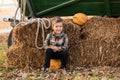 Cheerful little boy at pumpkin patch, fall time. portrait of small boys on hay with pumpkins Royalty Free Stock Photo