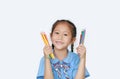 Cheerful little child girl in school uniform holding color pencils over white background. Education and school concept Royalty Free Stock Photo