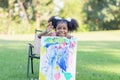 Cheerful little child girl shows her painting work. Cute kid show painting work in the garden Royalty Free Stock Photo