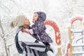 Cheerful little child plays with mother in a snowy park in winter Royalty Free Stock Photo