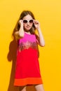 Cheerful little fashion girl posing with sunglasses Royalty Free Stock Photo