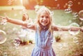 Cheerful little girl enjoying bubble blowing