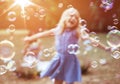 Cheerful little girl enjoying bubble blowing