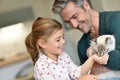 Cheerful little girl feeding cat Royalty Free Stock Photo