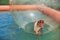 Cheerful little girl have fun inside of floating water walking ball Royalty Free Stock Photo