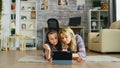 Cheerful little girl with her mother lying on the floor Royalty Free Stock Photo