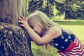 Cheerful little girl hiding behind tree Royalty Free Stock Photo