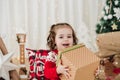 Cheerful little girl at home during christmas time holding gift box Royalty Free Stock Photo