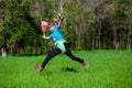 Cheerful little girl jump on the grass with a package Royalty Free Stock Photo