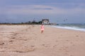 Cheerful little girl with long blonde hair in pink tulle skirt walking empty sea beach alone. Beautiful little princess Royalty Free Stock Photo