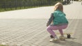 A little girl rides on a yellow skateboard