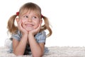 Cheerful little girl lying on the carpet