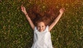 Cheerful little girl lying on green grass Royalty Free Stock Photo