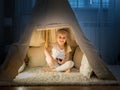 Little girl in teepee tent in room