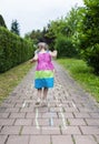 Cute cheerful little girl playing hopscotch on playground. Turning away from the camera Royalty Free Stock Photo