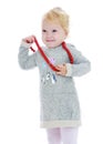 Cheerful little girl put on her big red beads Royalty Free Stock Photo