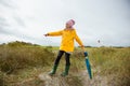 Cheerful little girl staying on beach with colorful ambrella on Baltic sea at windy rainy weather Royalty Free Stock Photo